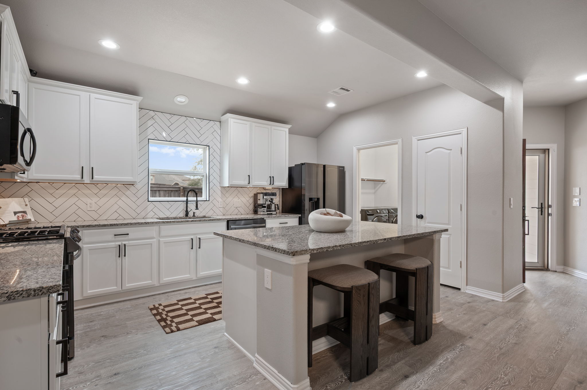 3724 Brean Down Road Pflugerville, TX 78660 - Photo 4 of 34 a kitchen with stainless steel appliances granite countertop a sink a stove a refrigerator cabinets and chairs