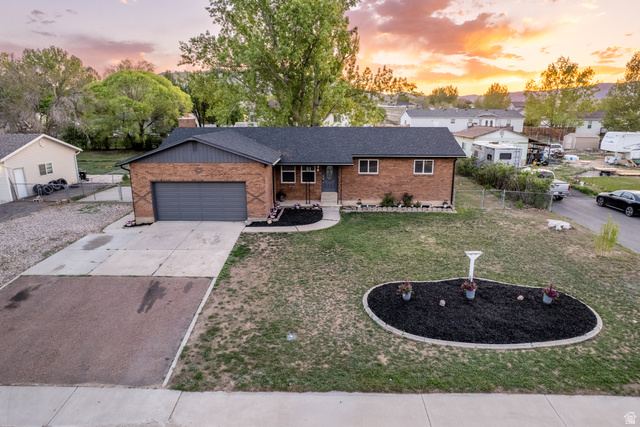 634 South 2100th Street West Vernal, UT 84078 - Photo 48 of 71 Brick exterior featuring a dark gray garage door, a black asphalt shingle roof, and a concrete driveway
