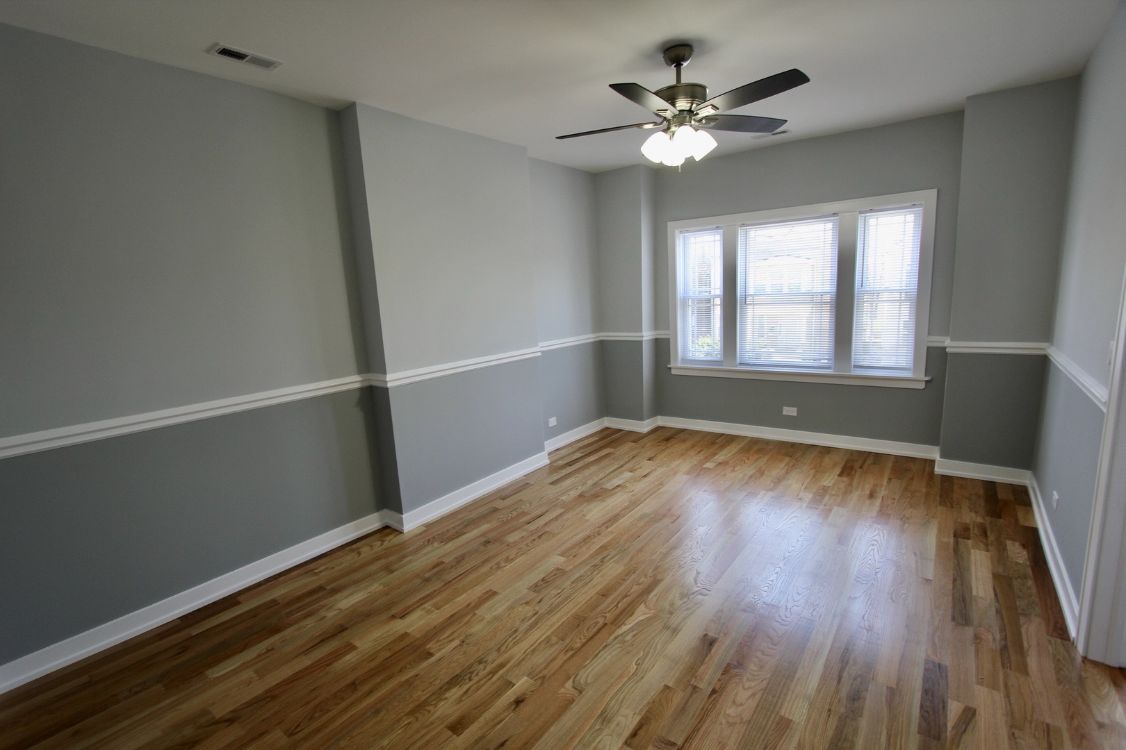 7413 South Princeton Avenue, Unit 1 Chicago, IL 60621 - Photo 16 of 24 an empty room with wooden floor and windows