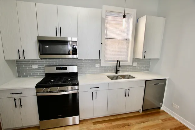 a kitchen with cabinets appliances a sink and a counter top