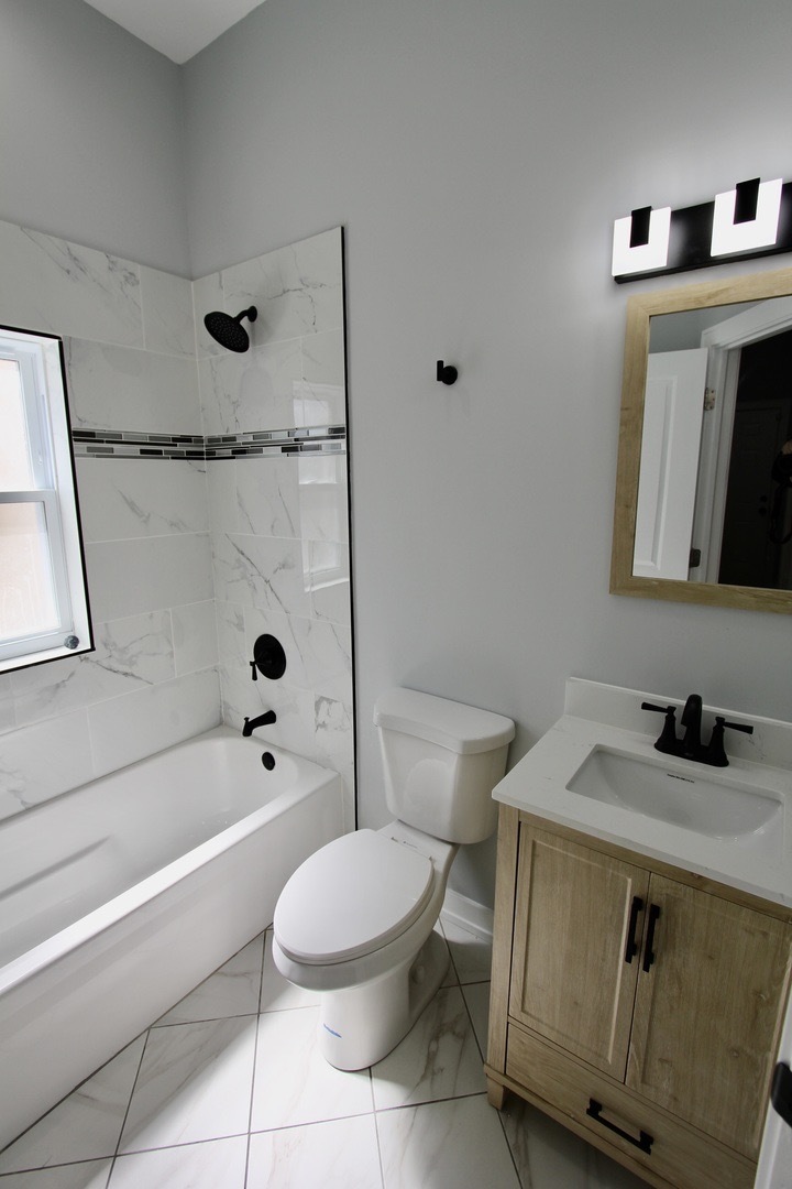 7413 South Princeton Avenue, Unit 1 Chicago, IL 60621 - Photo 10 of 24 a bathroom with a sink a toilet and shower