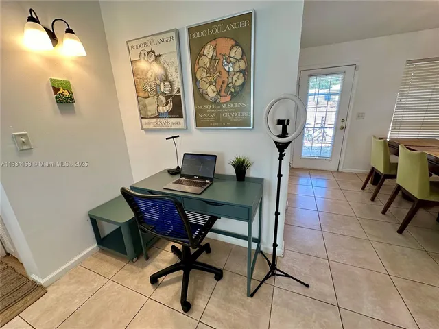 a view of a workspace with furniture and a window