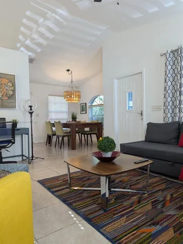 a living room with furniture a dining table and a chandelier