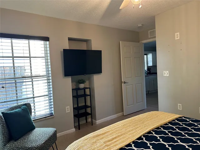 a bedroom with a bed and a television