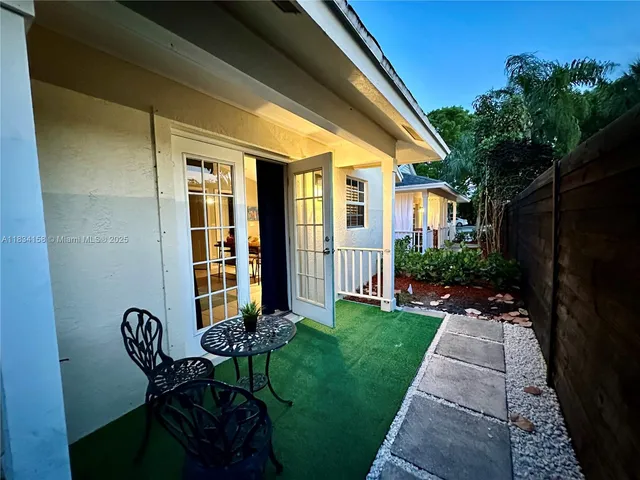 a view of patio with a table and chairs and potted plants
