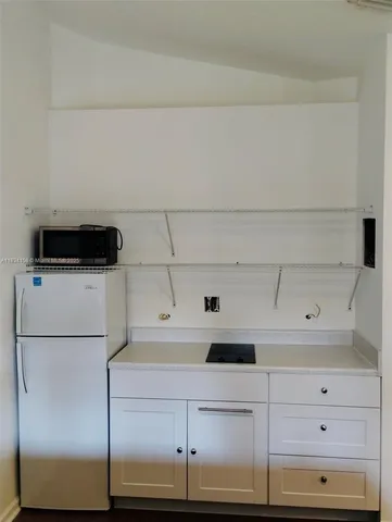 a kitchen with a refrigerator and cabinets