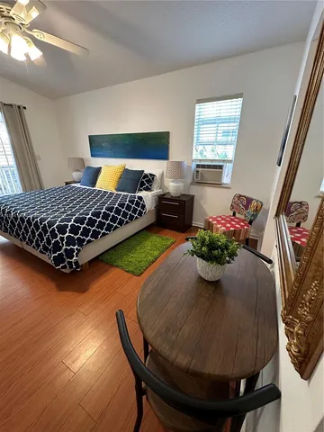 a bed sitting in a bedroom next to a window with potted plant
