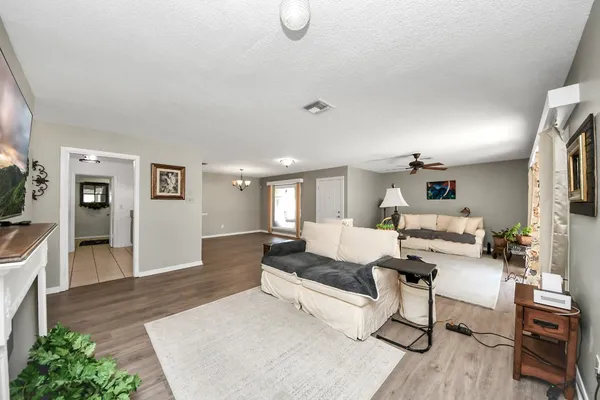 a living room with furniture and a wooden floor