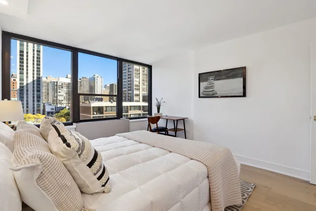 a bed sitting in a bedroom next to a large window
