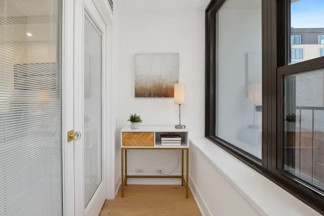 a view of an entryway with wooden floor and mirror