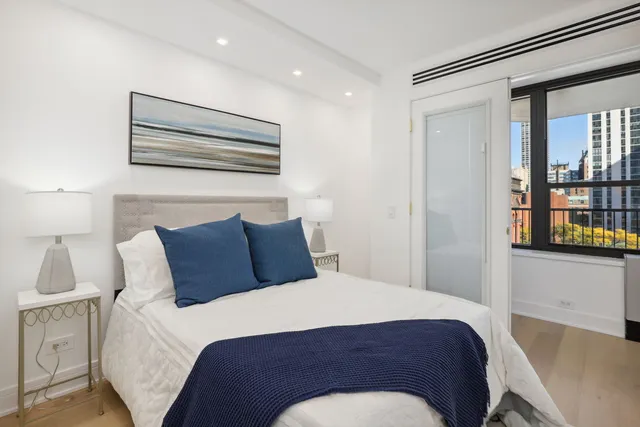 a large bed sitting in a bedroom next to a window