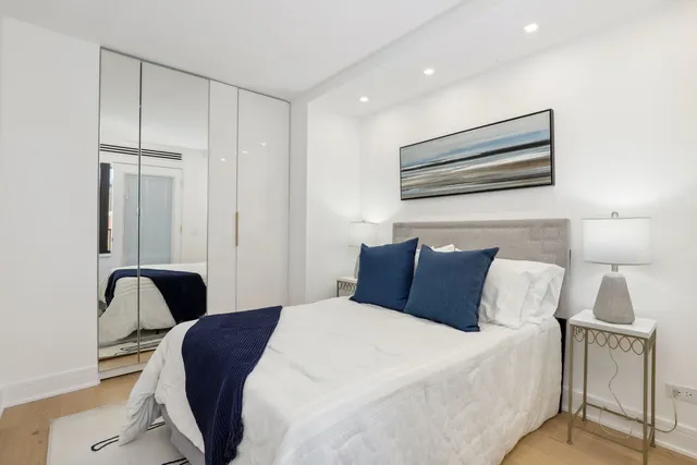 a bedroom with a bed and painting on the wall