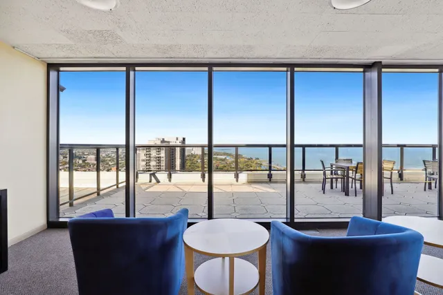 a view of a balcony with chairs and wooden floor