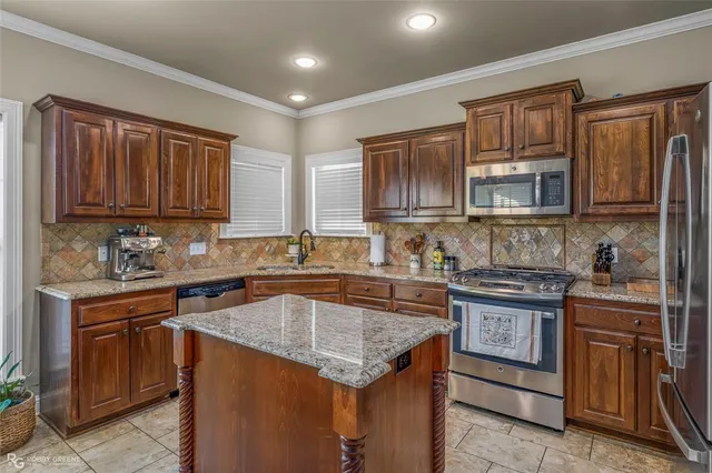 a kitchen with stainless steel appliances granite countertop a stove sink microwave and cabinets