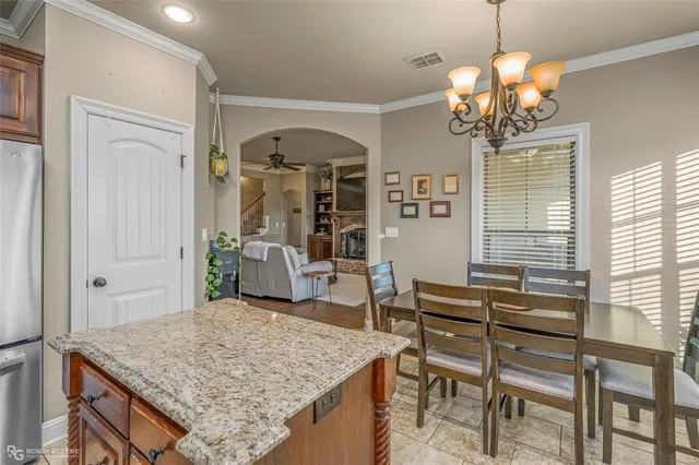 a dining room with wooden floor a chandelier a wooden table and chairs