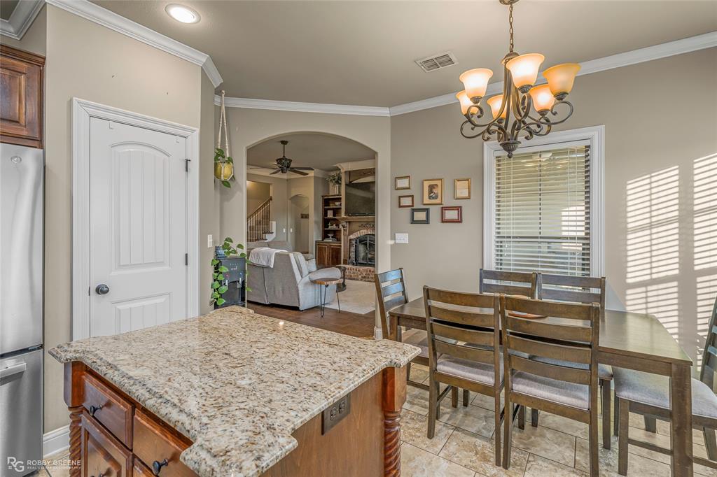 3034 Sagefield Lane Haughton, LA 71037 - Photo 10 of 28 a dining room with wooden floor a chandelier a wooden table and chairs