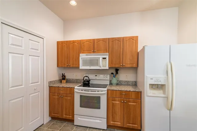 a kitchen with a refrigerator sink and cabinets