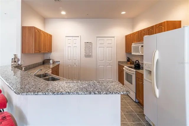a kitchen with stainless steel appliances granite countertop a refrigerator sink and stove