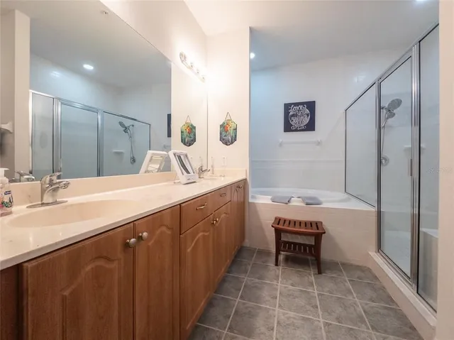 a large bathroom with a double vanity sink a large mirror and a bathtub