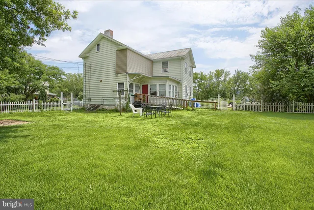 a view of a house with a big yard and sitting area