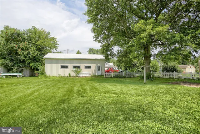 a view of a house with a big yard and large trees