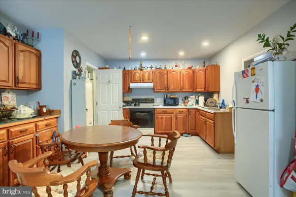 a kitchen with stainless steel appliances kitchen island granite countertop a refrigerator and a stove top oven