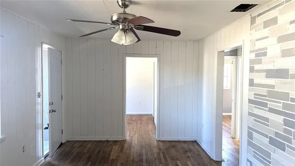 a view of a hallway with wooden floor and chandelier