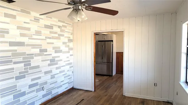a view of a hallway with wooden floor and cabinet