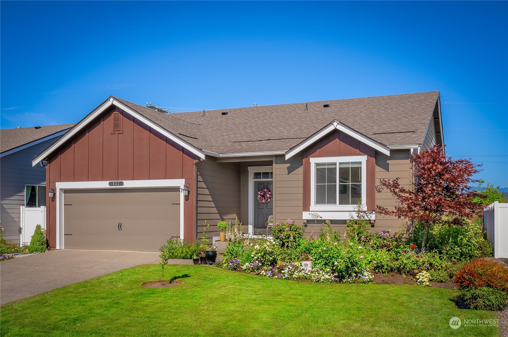 832 Maple Lane Southwest, Unit 59 Orting, WA 98360 - Photo 1 of 32 a front view of a house with a yard and garage