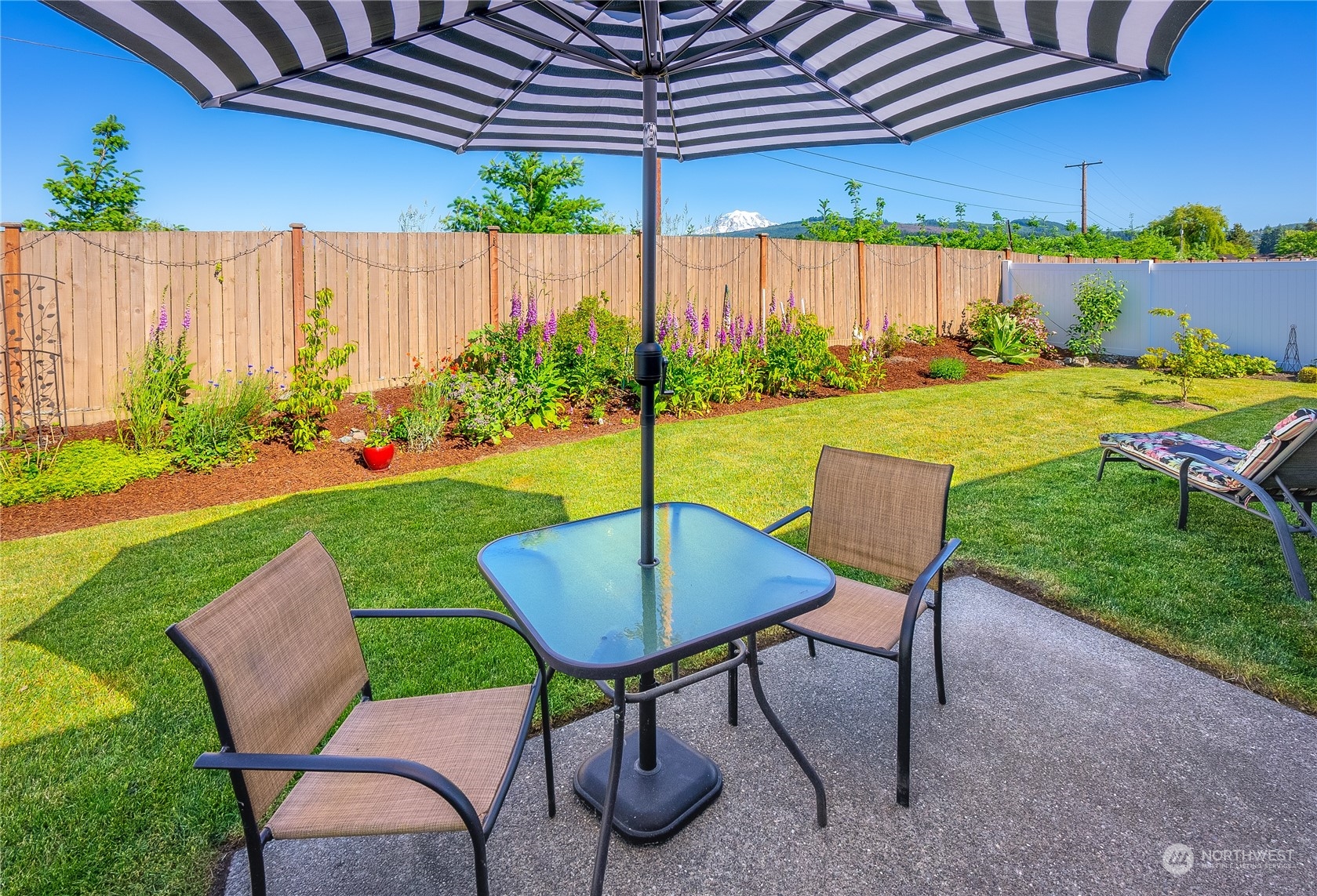 832 Maple Lane Southwest, Unit 59 Orting, WA 98360 - Photo 9 of 32 a view of a backyard with table and chairs under an umbrella