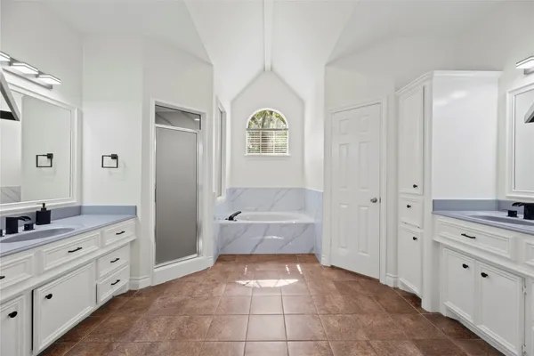 a bathroom with a tub a sink and a mirror
