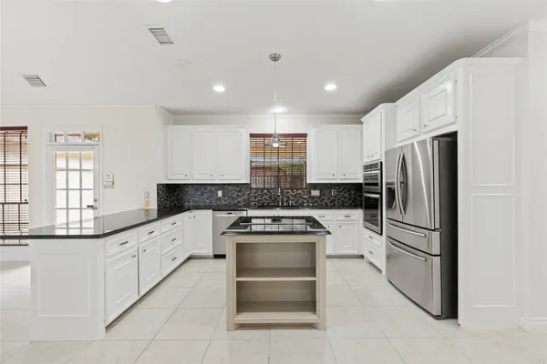 a kitchen with granite countertop a refrigerator and a stove