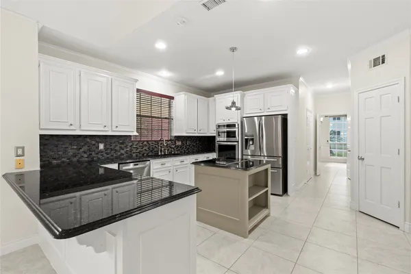 a kitchen with stainless steel appliances granite countertop a refrigerator and a stove top oven