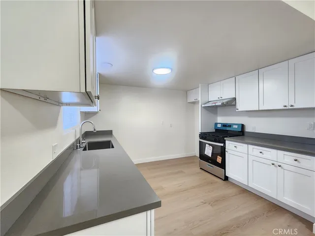a kitchen with stainless steel appliances granite countertop a sink stove and cabinets