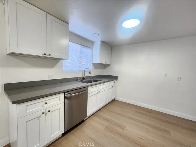 a kitchen with white cabinets and sink