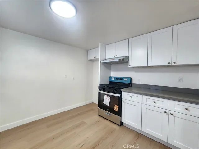 a kitchen with granite countertop white cabinets and stainless steel appliances