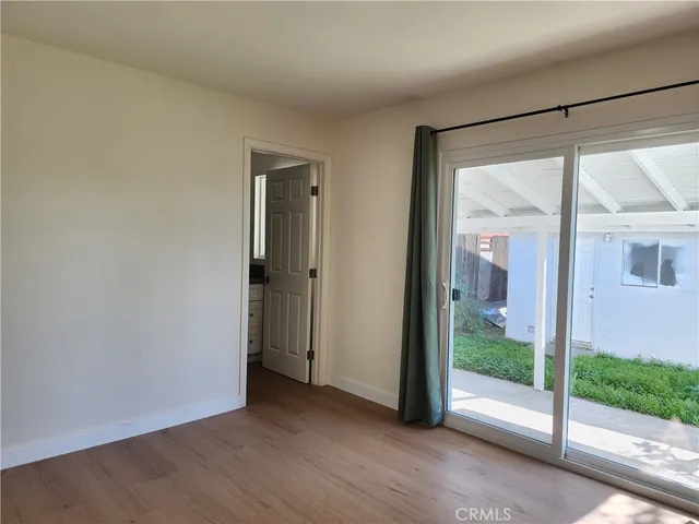 a view of a room with wooden floor and a window