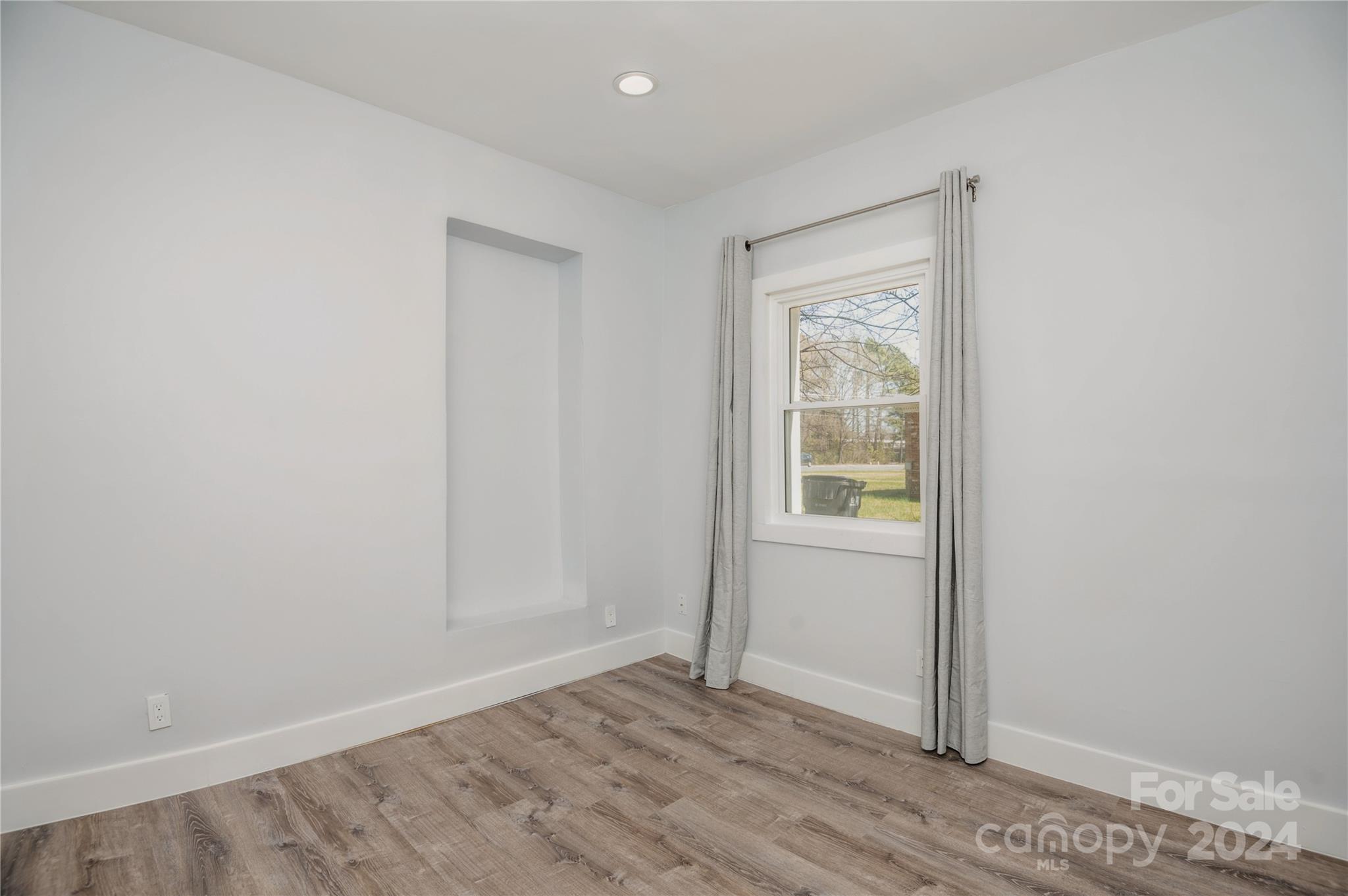 2124 Tyvola Road Charlotte, NC 28210 - Photo 25 of 38 a view of an empty room with wooden floor and a window