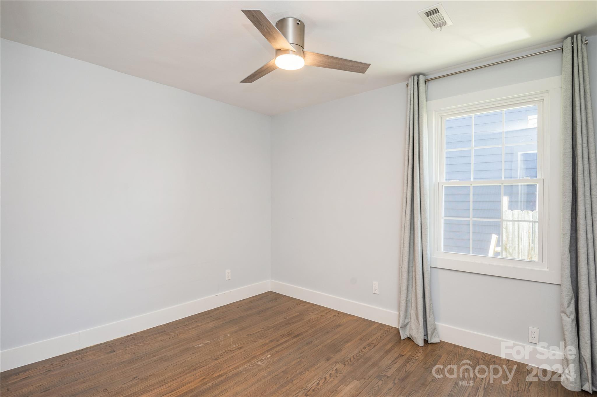 2124 Tyvola Road Charlotte, NC 28210 - Photo 26 of 38 an empty room with wooden floor fan and windows