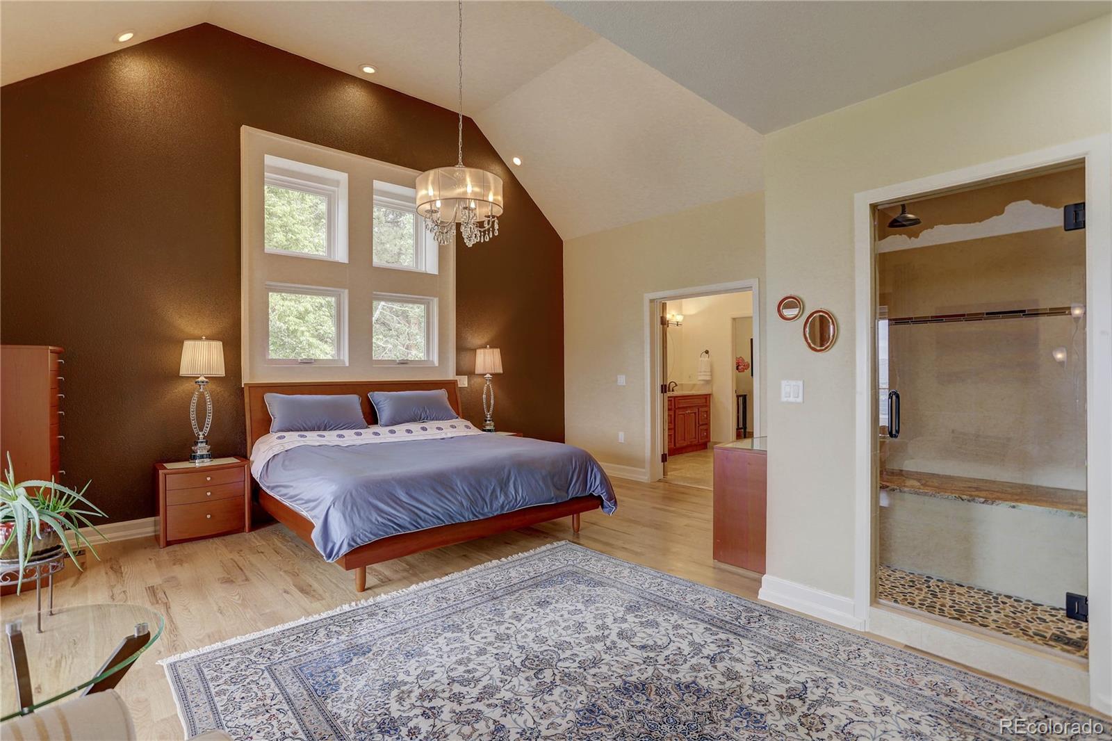 5886 Flagstaff Road Boulder, CO 80302 - Photo 18 of 37 a spacious bedroom with a bed and a dresser with mirror