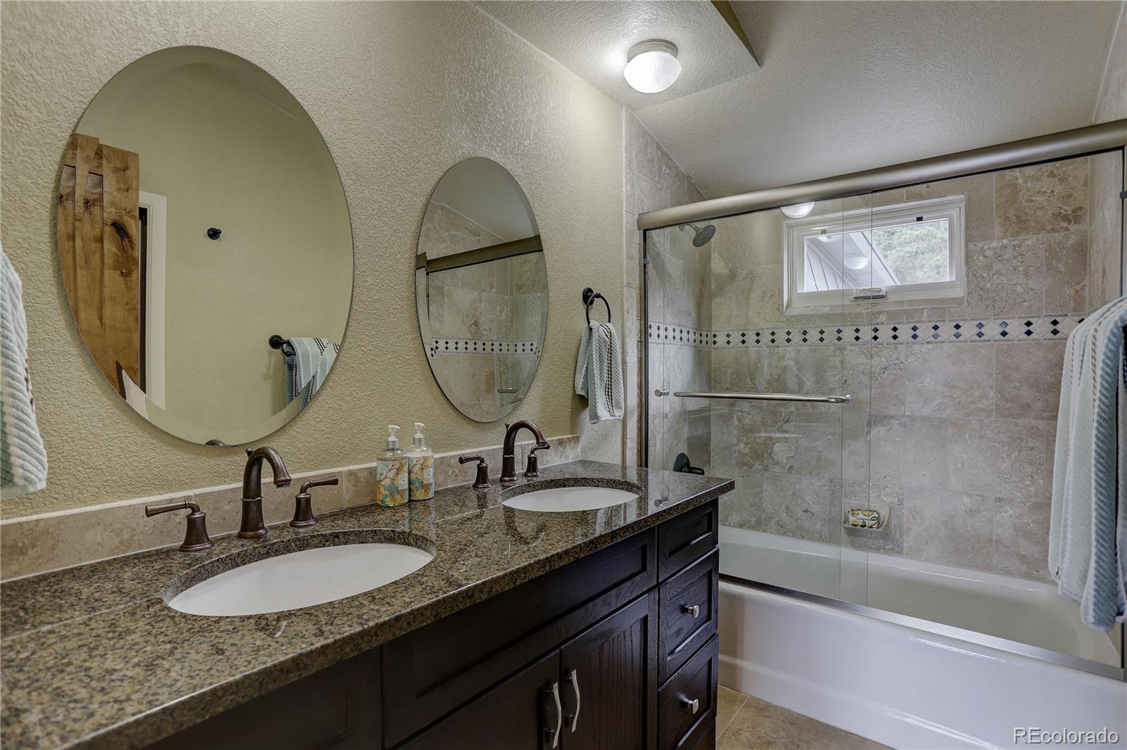 5886 Flagstaff Road Boulder, CO 80302 - Photo 26 of 37 a bathroom with a granite countertop sink a mirror and a bathtub