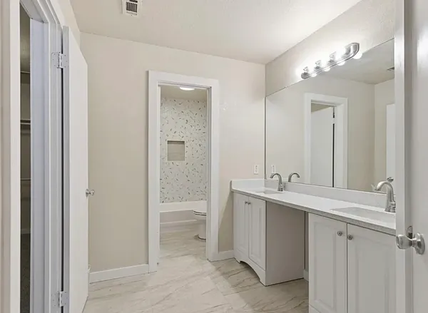 a bathroom with a double vanity sink and mirror with shower