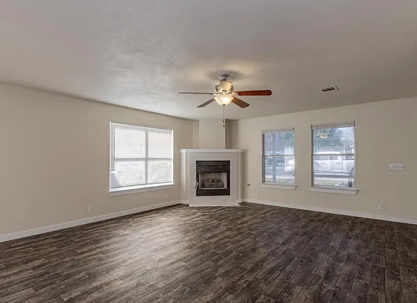 a view of an empty room with a fireplace and a window