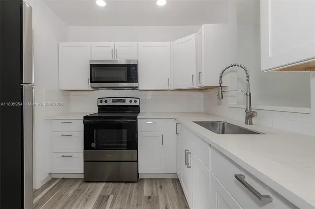 a kitchen with granite countertop a sink and a stove top oven