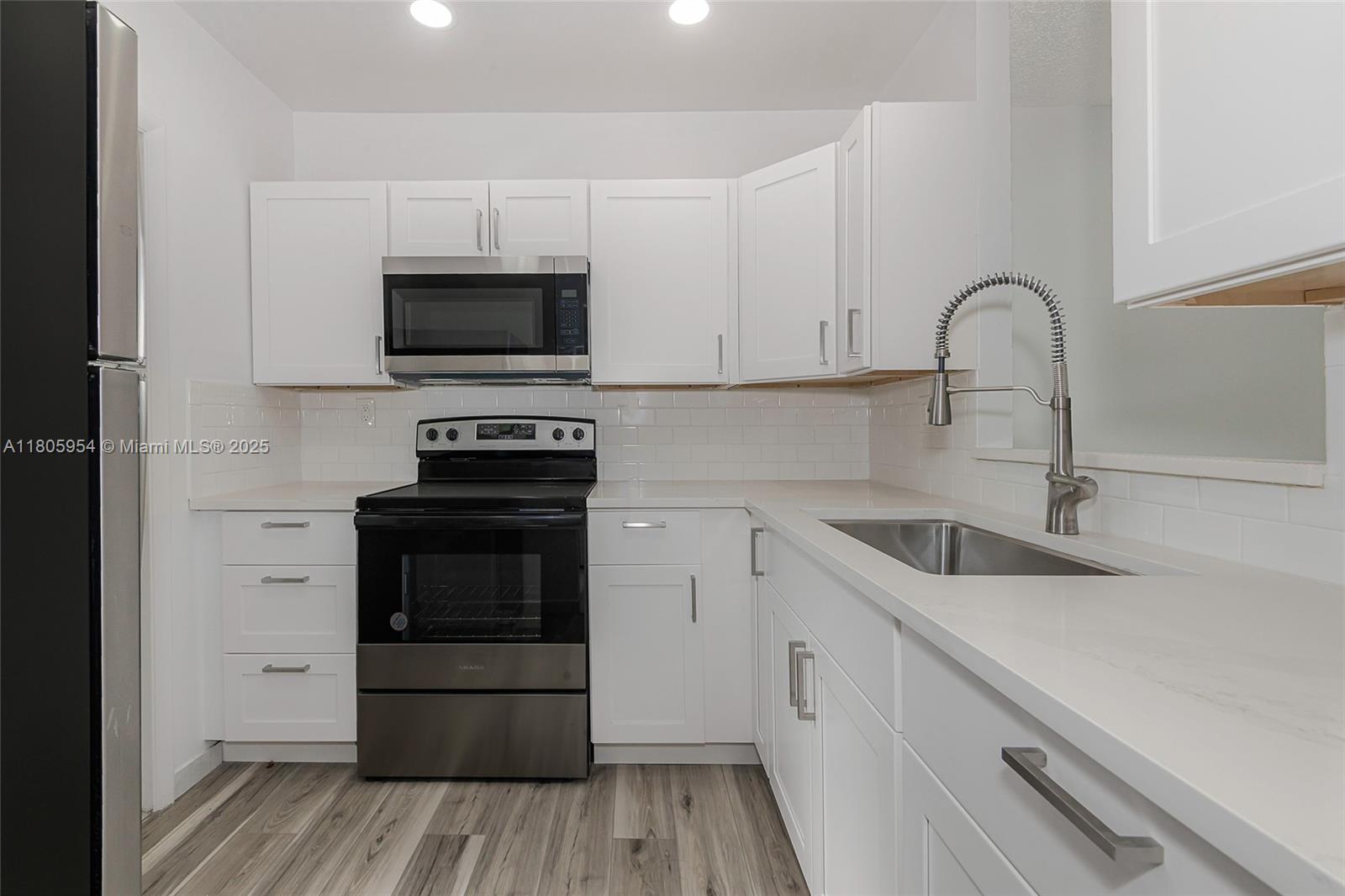 a kitchen with granite countertop a sink and a stove top oven