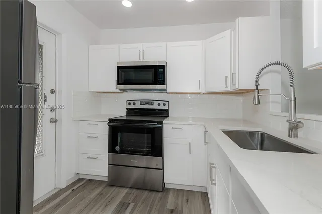 a kitchen with a sink and steel appliances