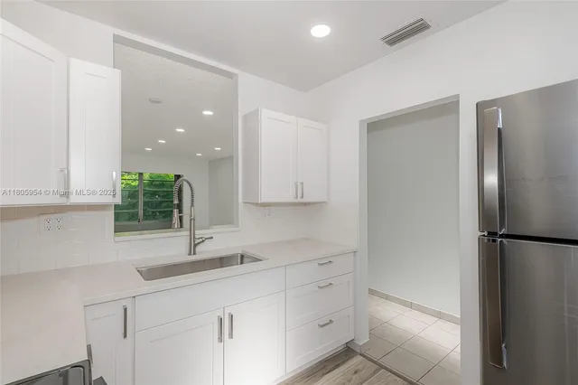 a kitchen with a refrigerator and a sink