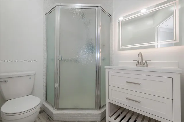 a bathroom with a shower a sink a toilet and a mirror