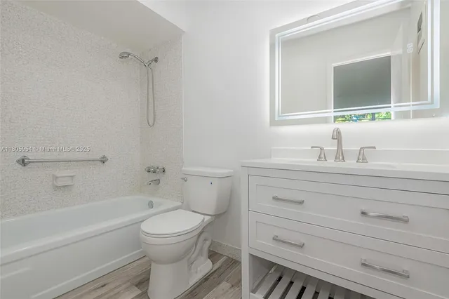 a bathroom with a toilet a sink a mirror and bathtub