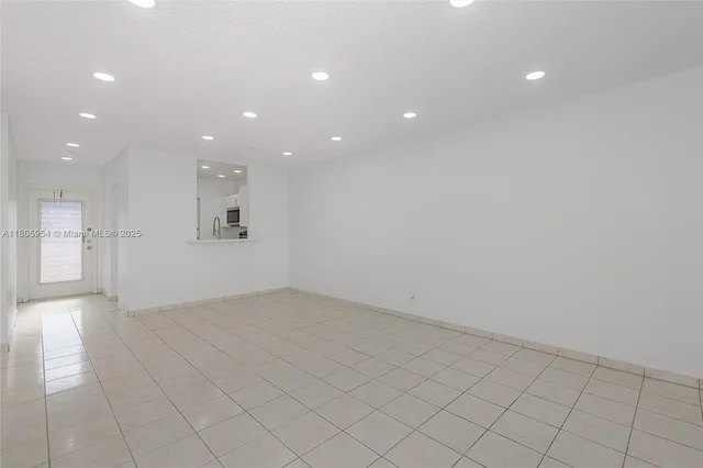 an empty room with white walls and windows